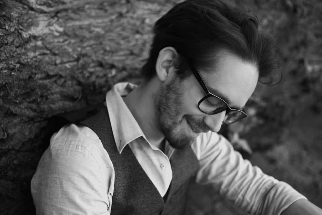 Mann mit Brille und Bart lächelnd im Profil - Zwergriese - Poetry Slammer & Moderator aus Essen