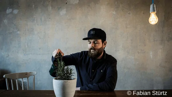 Autor Patrick Salmen mit Gießkanne und Avocado - Pressefoto